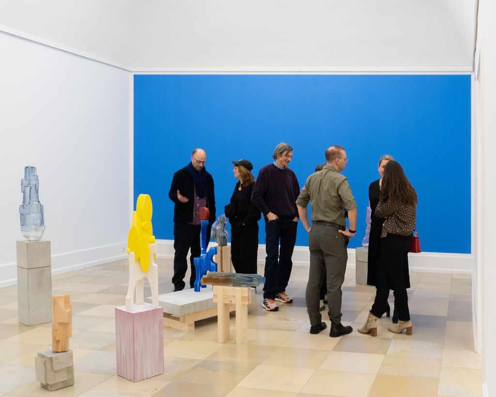 Glas- und Keramikobjekte von Kai Schiemenz vor einer Wand, die Himmelblau simuliert