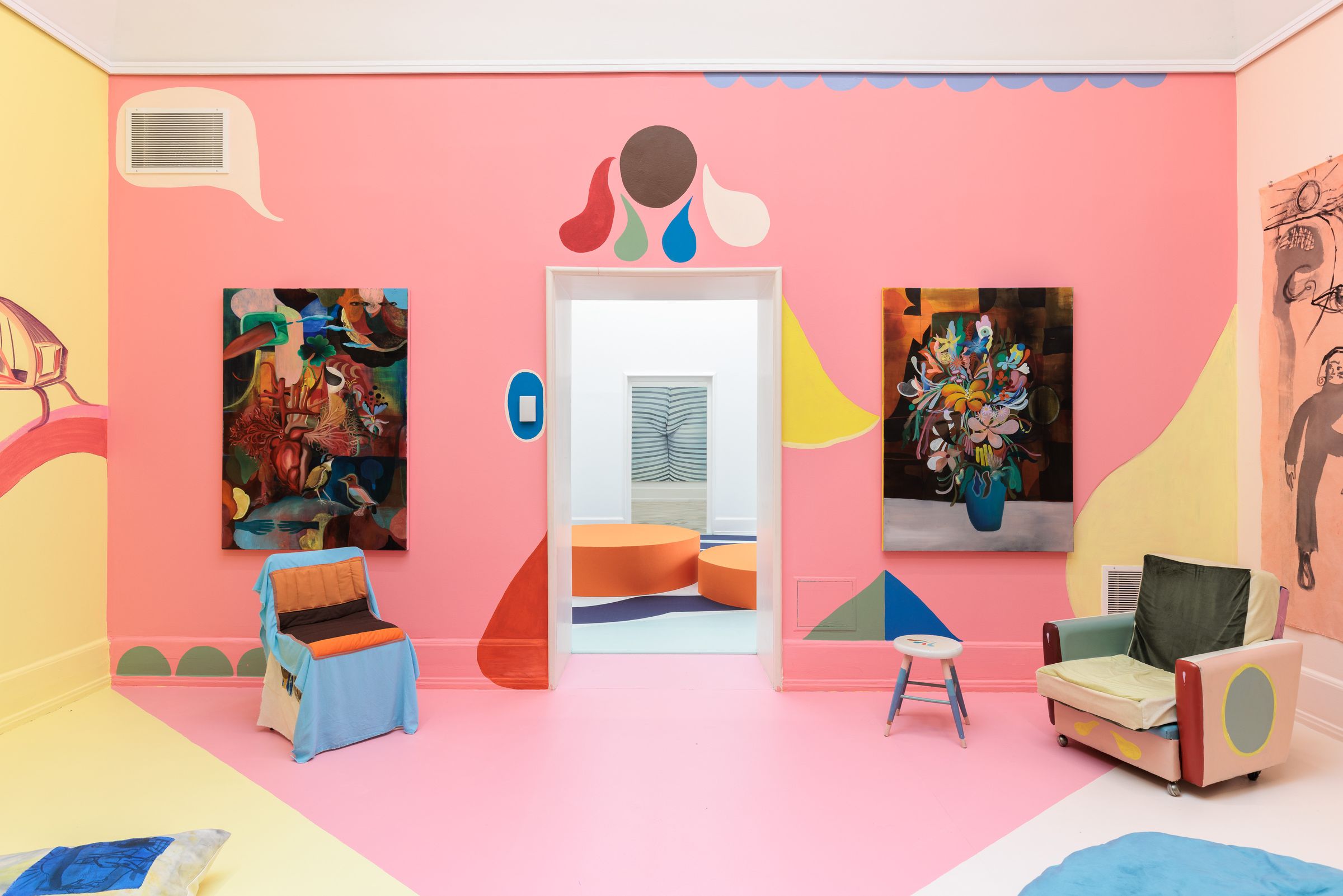 Farbig gestaltete Wand von Monika Michalko in Rosa mit kleinen zeichnerischen Setzungen und zwei großformatigen Gemälden: links ein Herz umgeben von Vögeln und Pflanzen, rechts ein bunter Blumenstrauß vor schwarzem Hintergrund