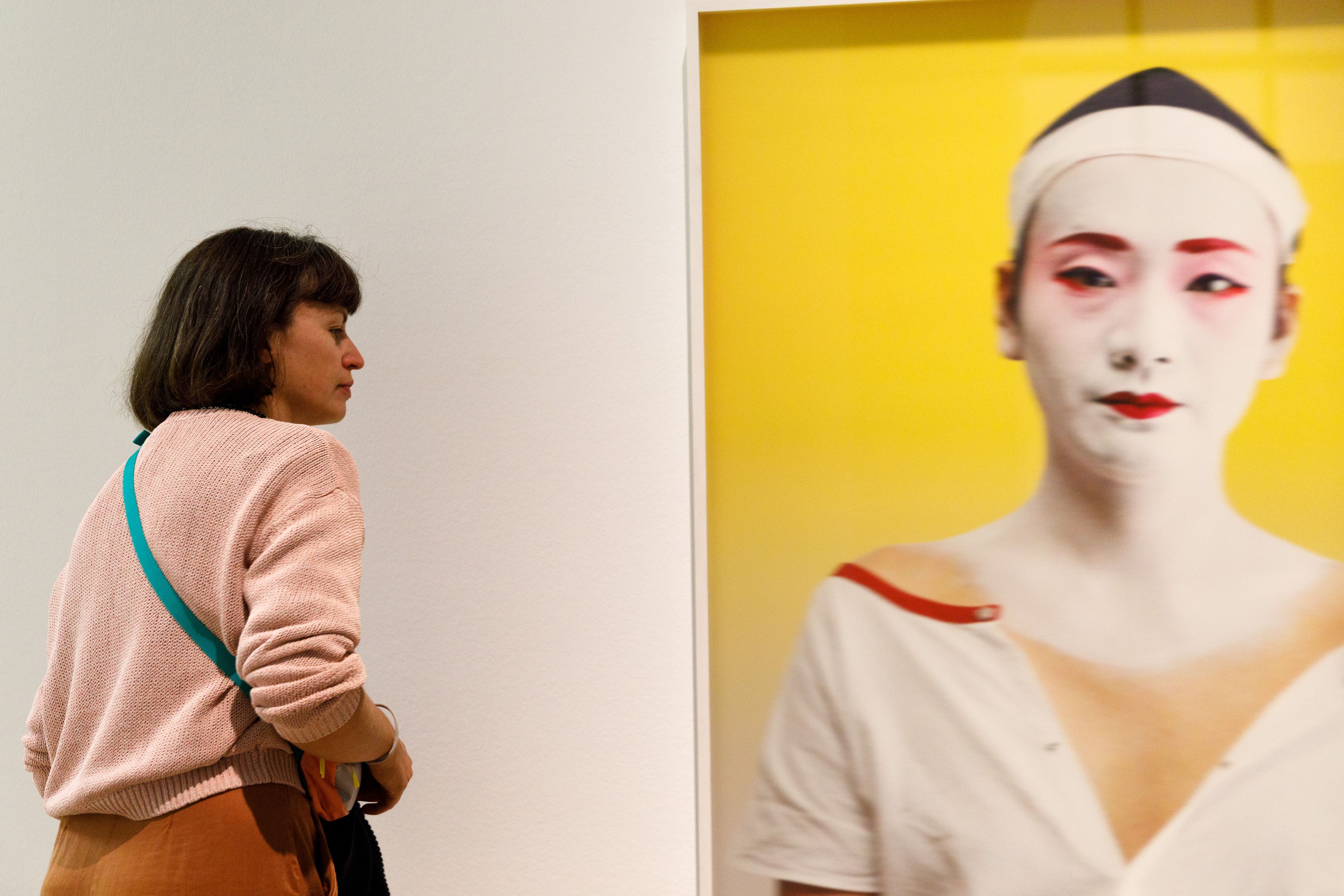 Überlebensgroßes Porträtfoto der einzigen männlichen Geisha Japans vor gelbem Hintergrund